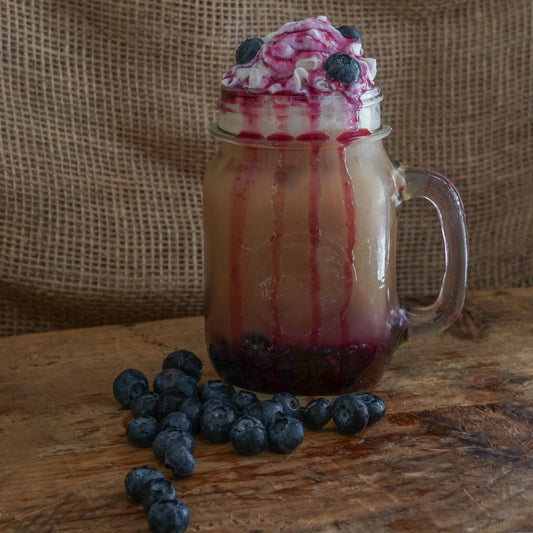 Blueberry flavored coffee drink next to fresh blueberries